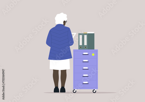 Employee Organizing Files in a Modern Office Setting, A person stands by a file cabinet, sorting documents at work