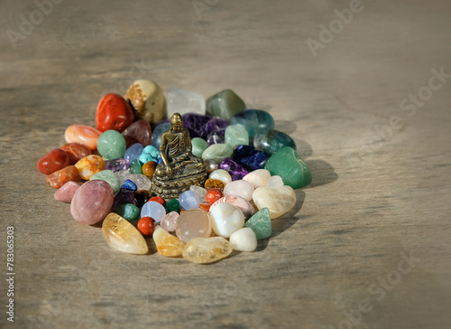 set of colorful minerals and bronze Buddha figurine on wooden background. different gemstones for Crystal magic ritual. spiritual esoteric practice, meditation for relax, Harmony, life balance