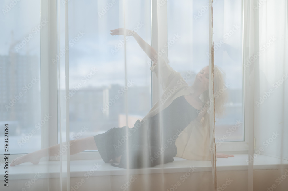 Caucasian woman dancing modern dance on the windowsill. Caucasian woman dancing modern dance on the windowsill.