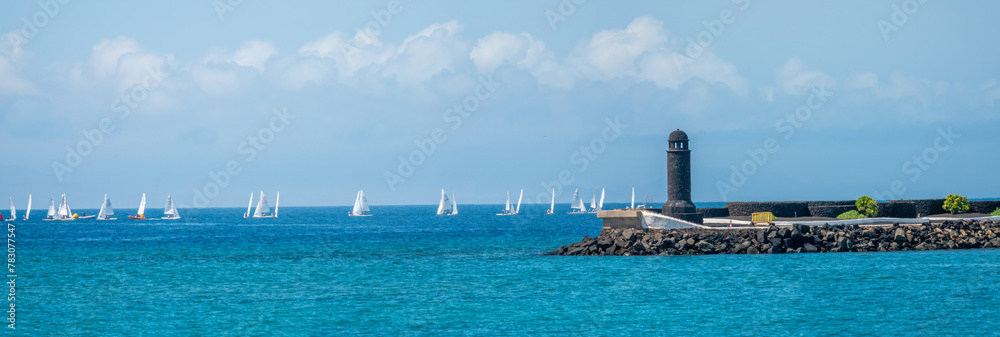 Φωτογραφία Regatta past the lighthouse at the entrance of the Arrecife harbor, Lanzarote, C
