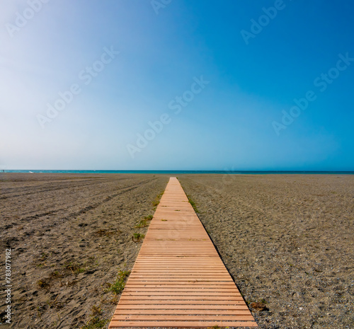 Boardwalk on a bearch in Motril, Andalusia, Spain. In its minimalistic simplicity it seems to point to the horizon photo