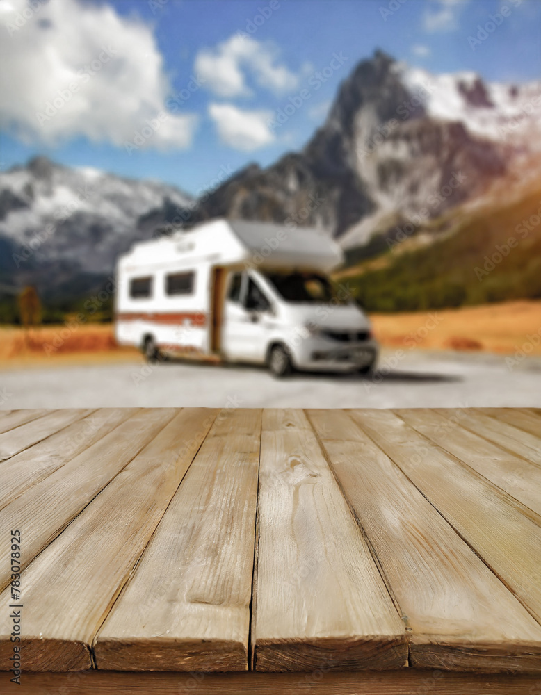 Φωτογραφία Wooden table in the tent and blurred motorhome at sunset in the mountain near the lake