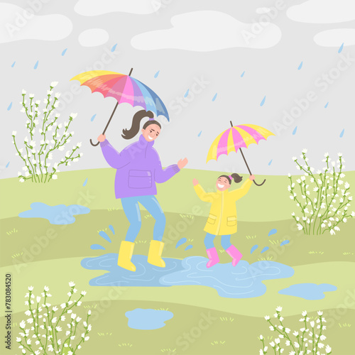 Happy mother and daughter jumping in puddle at springtime in flat cartoon design. Mom and kid in raincoats and under umbrellas playing in splashing drops by blooming trees at park. Vector illustration