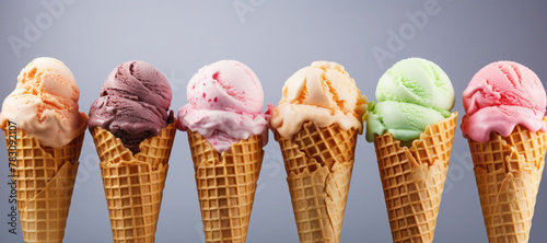 Assorted fresh delicious ice creams in waffle cones on grey background. Banner. Copy space for text. Mockup