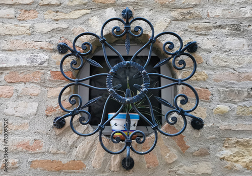 Inferriata rotonda in ferro battuto con vaso di fiori in ceramica colorata