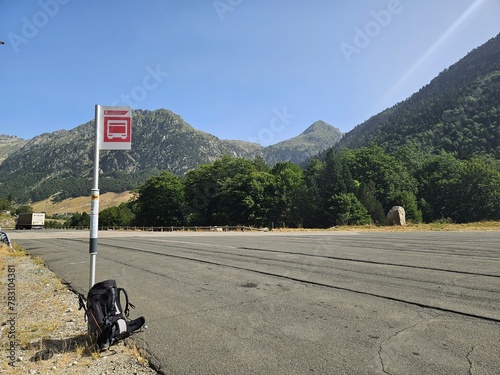 Sac posé à un arrêt de bus le long d'une route devant un paysage de montage. La fin d'une randonnée ou un transfert vers un depart photo