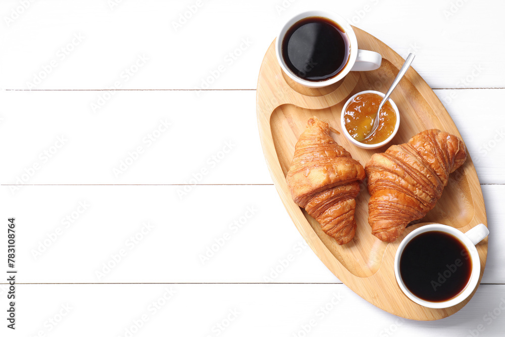 Tasty breakfast. Cups of coffee, jam and croissants on white wooden table, top view. Space for text