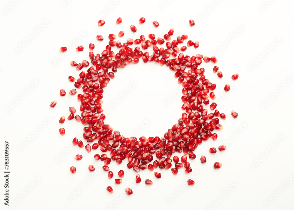 Frame made of ripe juicy pomegranate grains on white background, top view. Space for text Frame made of ripe juicy pomegranate grains on white background, top view. Space for text