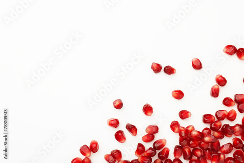 Many ripe juicy pomegranate grains on white background, flat lay. Space for text