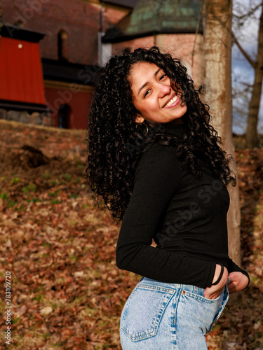 Model shoot in a park of a charming curly-haired Latina girl with a cute face