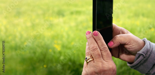 Close up of hands taking pictures outdoor with a smartphone  photo