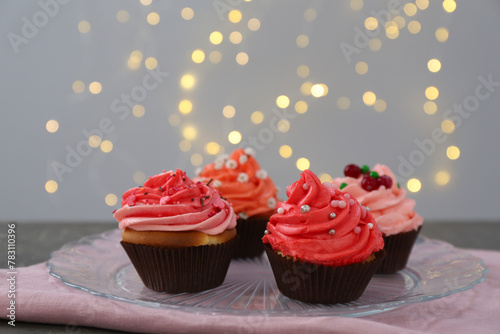 Delicious cupcakes with pink cream on grey table
