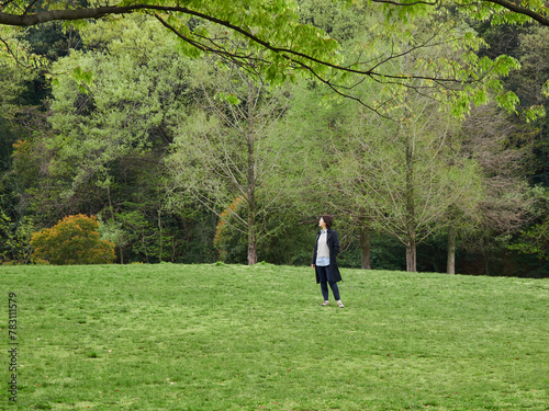 春の新緑の公園で散歩する一人の女性の様子 © zheng qiang