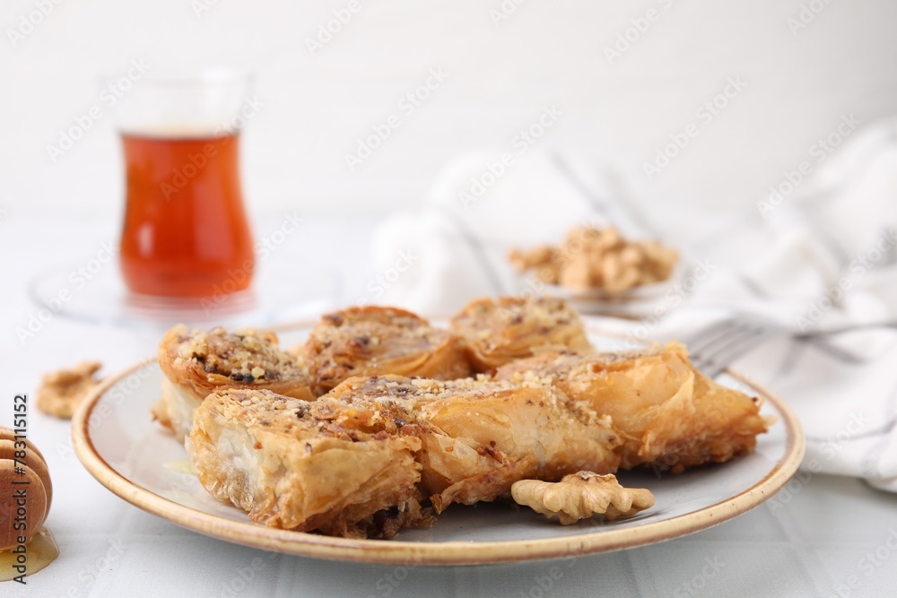 Eastern sweets. Pieces of tasty baklava on white tiled table, closeup Eastern sweets. Pieces of tasty baklava on white tiled table, closeup