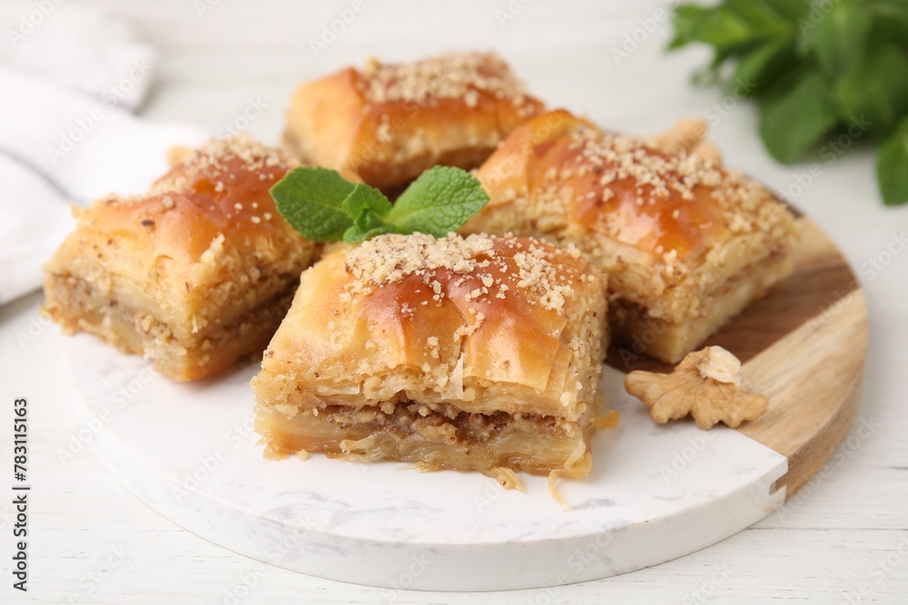 Eastern sweets. Pieces of tasty baklava on white wooden table, closeup