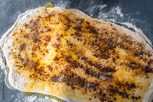 Teig wird in der Küche mit geschmolzener Butter und Zimt bestrichen photo