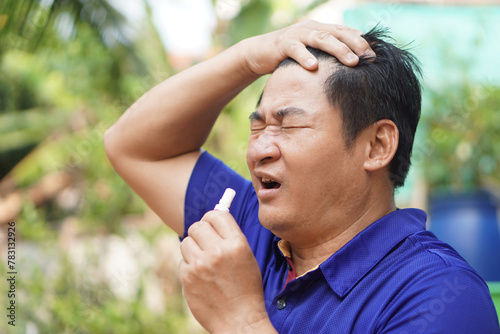 Asian man feel hot, unwell, use menthol inhaler to smell for relief symptom from hot weather. Concept, self first aid to protect from heat stroke. Refreshing. 