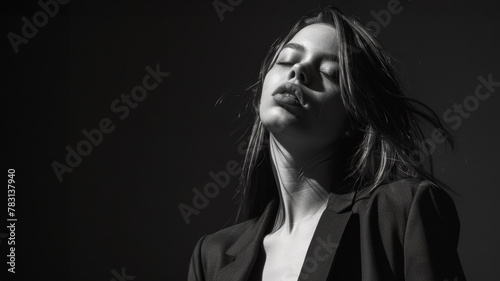 portrait noir et blanc studio d'un jeune femme en tailleur noir, espace pour texte photo