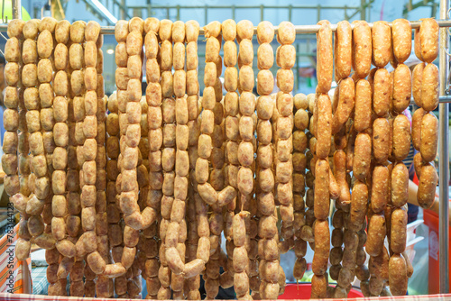 Pork and rice sausage or fermented hot dog northeastern isan thai style hanging in hawker stall for sale © ake1150