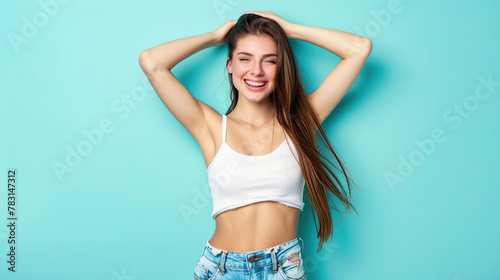 Portrait of a happy young girl celebrating success on pastel blue background