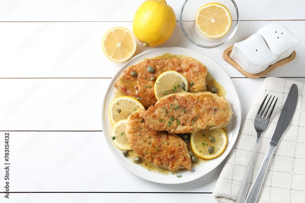 Delicious chicken piccata served on white wooden table, flat lay. Space for text