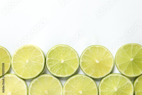 Fresh juicy lime slices on white background, flat lay. Space for text