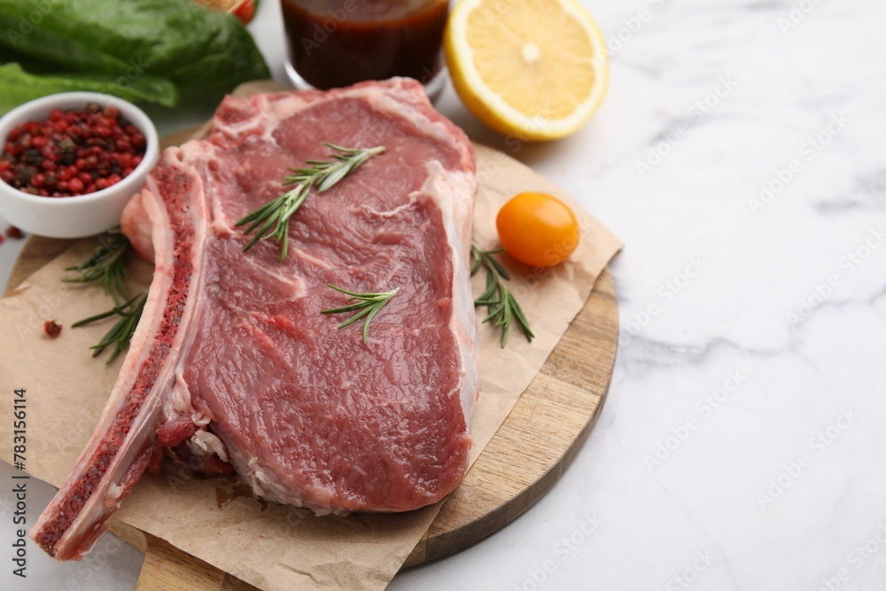 Raw meat, rosemary and products on white marble table, closeup. Space for text