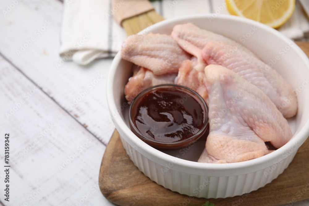 Fresh marinade and raw chicken wings on rustic wooden table, closeup. Space for text Fresh marinade and raw chicken wings on rustic wooden table, closeup. Space for text