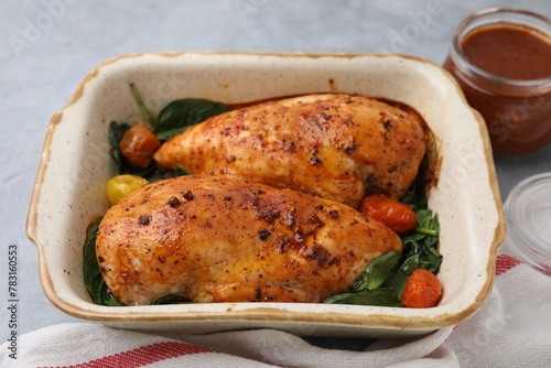 Baked chicken fillets with vegetables and marinade on grey table, closeup