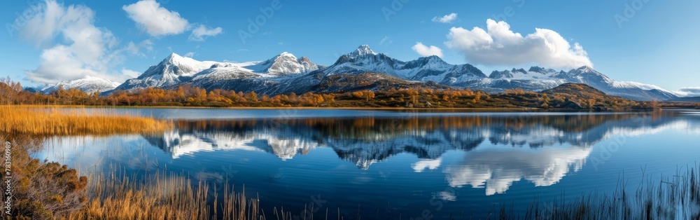 A beautiful lake with mountains in the background. The water is calm and the sky is clear. The reflection of the mountains in the water creates a serene and peaceful atmosphere