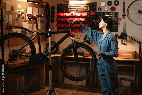 Female mechanic repairing a mountain bike in a workshop