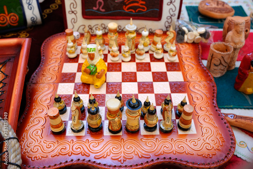 Chess pieces made in traditional Kyrgyz style in folk costumes, set on a chessboard