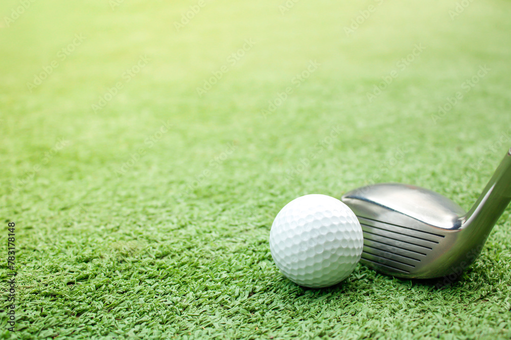 Golf balls and tees are placed on artificial grass.