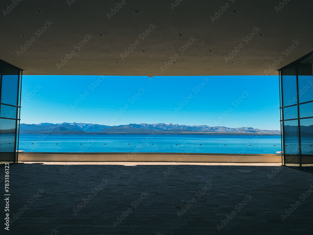 A large open space with a view of the ocean and mountains. The sky is clear and blue