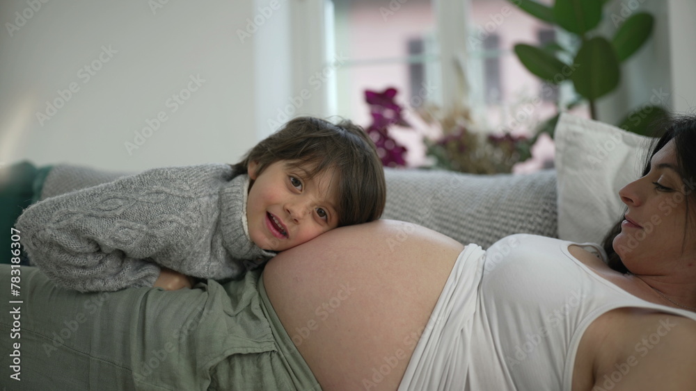 Beautiful maternal scene of pregnant mother bonding with son. 5 year old boy interacting with mom's belly during third trimester of pregnancy, authentic family relationship Beautiful maternal scene of pregnant mother bonding with son. 5 year old boy interacting with mom's belly during third trimester of pregnancy, authentic family relationship