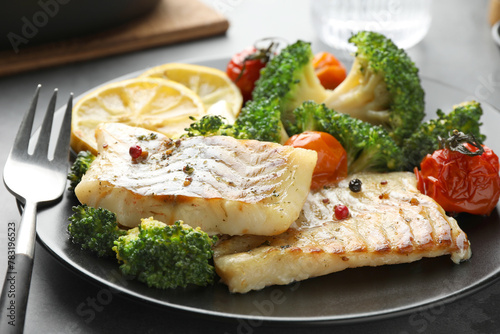 Tasty cod cooked with vegetables served on grey table, closeup