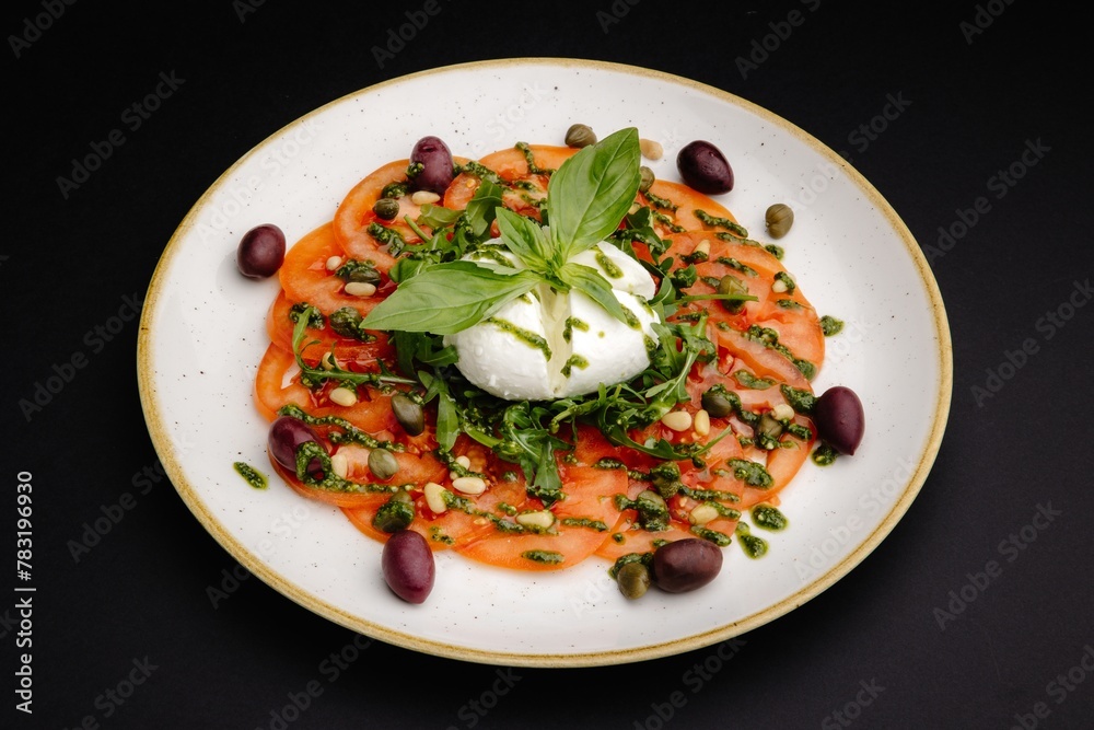Fresh Heirloom Tomatoes with Burrata Cheese and Basil Leaves on Black Background Fresh Heirloom Tomatoes with Burrata Cheese and Basil Leaves on Black Background