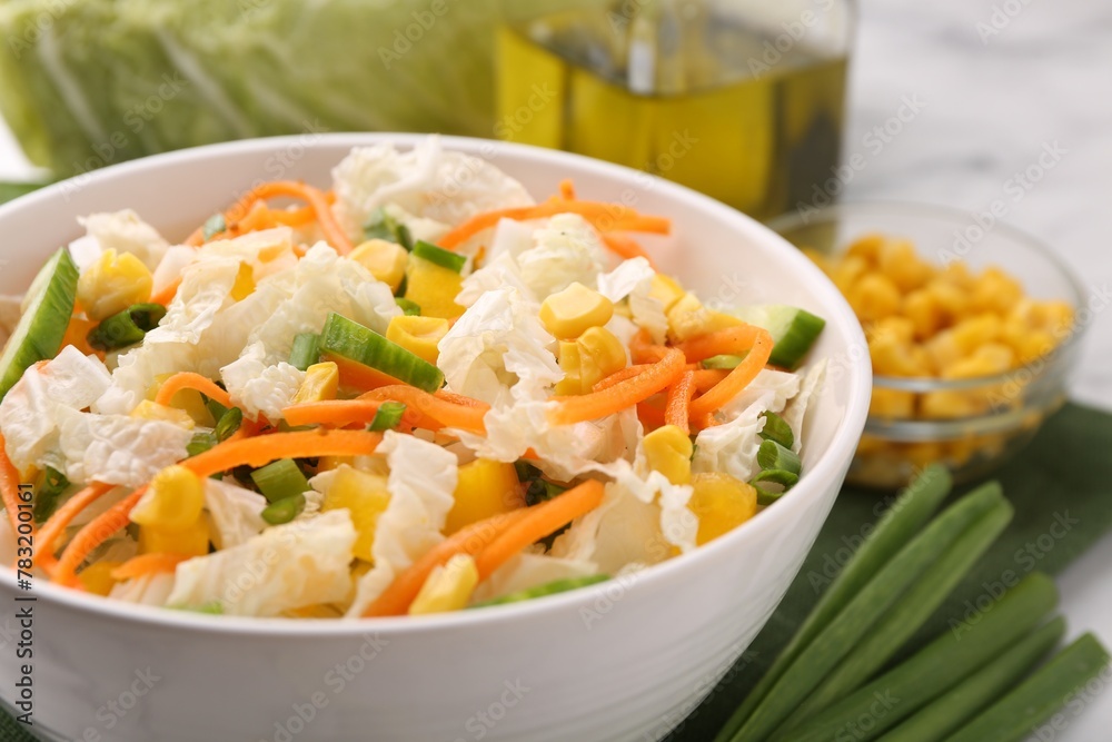 Tasty salad with Chinese cabbage, carrot, corn and cucumber in bowl on table, closeup