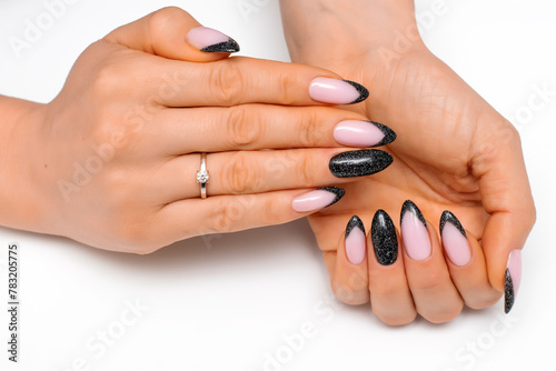  Festive manicure. Black shiny manicure on long sharp nails close-up on a white background. Reflective design.