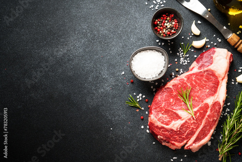 Meat steak. Beef steak dry aged with spices on black background. Top view. © nadianb