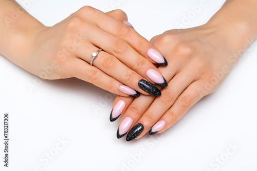 Festive manicure. Black shiny manicure on long sharp nails close-up on a white background. Reflective design.