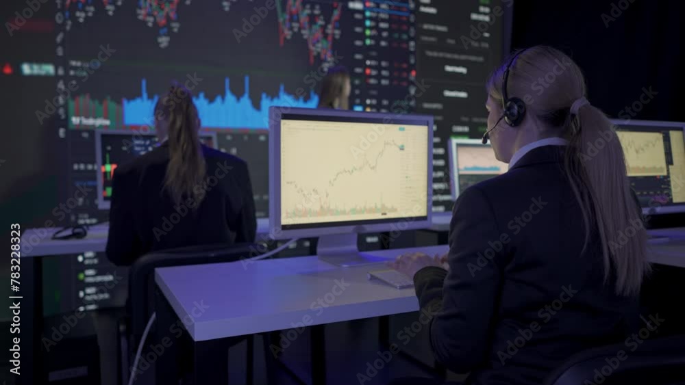 Successful business people in the office. Team of brokers and ceo top manager in front of big digital screen with stock exchange charts working on computers. Successful business people in the office. Team of brokers and ceo top manager in front of big digital screen with stock exchange charts working on computers.