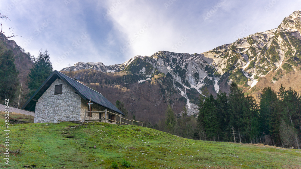 Italian valley of the Rio Nero whit its hut at sunset on a winter day with snowy mountains Italian valley of the Rio Nero whit its hut at sunset on a winter day with snowy mountains