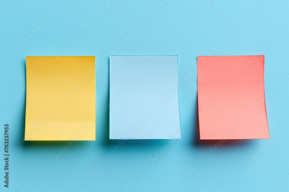 Fototapeta premium Three Different Colored Sticky Notes on a Blue Background