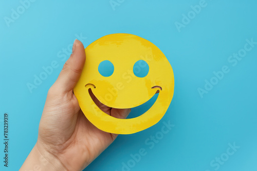 Hand Holding Yellow Paper Smiley Face photo