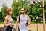 A man and woman in sportswear exercise outdoors, showcasing determination and motivation.