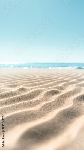 Abstract beach background, clear and soft blue sky with smooth fine sand of delicate color. In the foreground of the painting is a large area of ​​beige fine sand with wavy ripples on it.