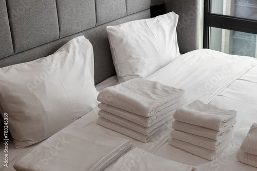 Clean towels on the bed in a hotel room, the bed iwith clean white pillows and sheets in the apartment. Close-up photo