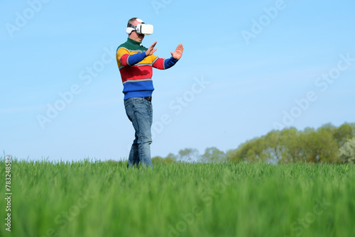 Male using virtual reality on agricultural land of the blue sky on the background, low viewing angle. Digital agriculture business. outdoors. space for text