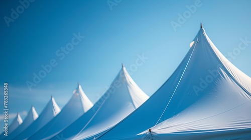 Peaks of tents against clear blue sky on a sunny day